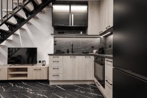 a kitchen with wooden cabinets and stainless steel appliances at Signature Luxury Loft in Volos