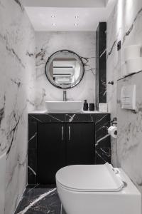 a bathroom with a toilet and a sink and a mirror at Signature Luxury Loft in Volos +22 photos