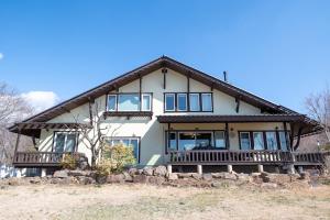 a large white house with a gambrel roof at ReTune Hokuto in Hokuto