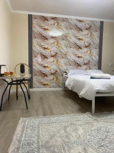 a bedroom with a bed and a stone wall at Green apple in Almaty +5 photos