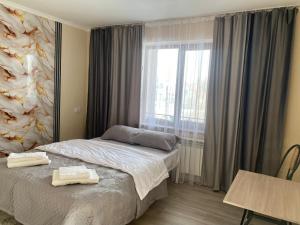 a hotel room with a bed and a window at Green apple in Almaty