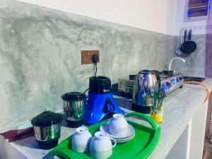a kitchen counter with a counter top with a blue and green coffee maker at Frida Cove in Weligama