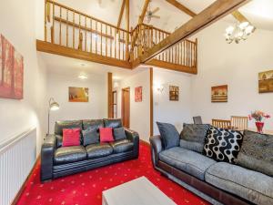 a living room with two leather couches and a red carpet at The Old Drapery - Uk43568 in Haltwhistle