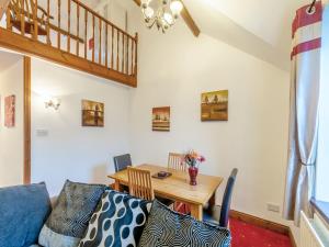 a living room with a blue couch and a wooden table at The Old Drapery - Uk43568 in Haltwhistle