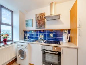 a kitchen with a sink and a washing machine at The Old Drapery - Uk43568 in Haltwhistle +5 photos