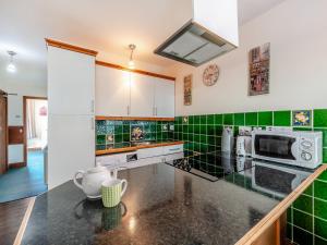 a kitchen with green tiles on the wall at The Drovers Rest - Uk43567 in Haltwhistle
