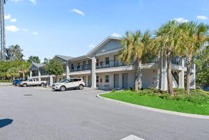 a white car parked in front of a building at Baymont by Wyndham Ocala Suites in Ocala