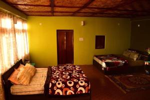 a bedroom with two beds in a room with yellow walls at Bungbakha Homestay in Singtām