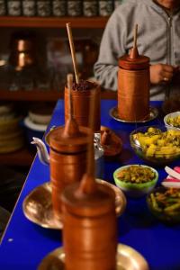 a table topped with bowls of food with wooden utensils at Bungbakha Homestay in Singtām