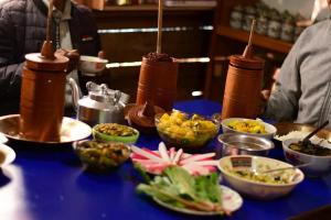 a table topped with bowls of food on a blue table at Bungbakha Homestay in Singtām
