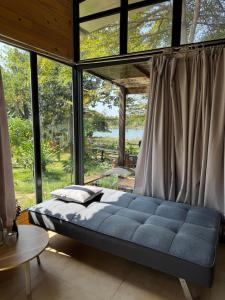a bed in a room with a large window at Bình An lake view in Buon Ma Thuot