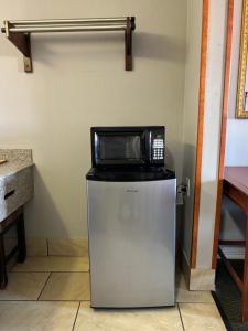 a microwave sitting on top of a refrigerator at Royal Inn Linden in Linden
