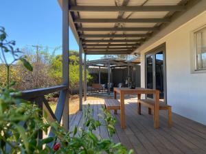 a wooden deck with a table and benches on it at Private 3Bed Home with Large Deck Central Location in Eaglehawk