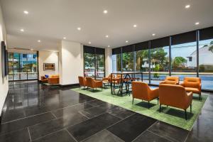 a lobby with chairs and tables and windows at Quest Chatswood in Sydney