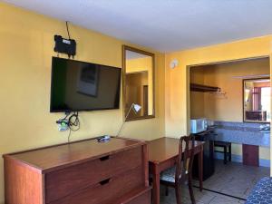 a room with a desk with a television on the wall at Royal Inn Linden in Linden
