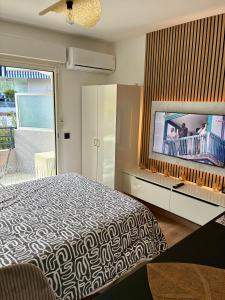 a bedroom with a bed and a flat screen tv at Studio cuisine parking piscine à Cannes in Cannes