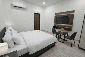 a bedroom with a bed and a desk and a television at BODHI Residency in Greater Noida
