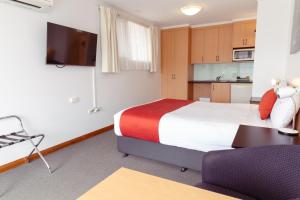 a hotel room with a bed and a kitchen at Barclay Motor Inn in Devonport