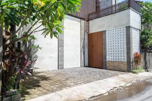 a house with a wooden door on a street at Lumbung Sari Studio in Ngurah Rai International Airport +34 photos
