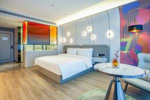 a bedroom with a bed and a table and a couch at Ibis Styles Nantong North High-tech Zone in Nantong +37 photos