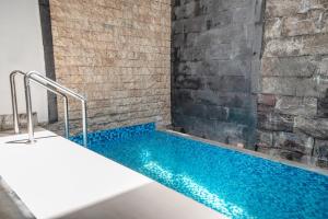 a swimming pool in a room with a brick wall at Lumbung Sari Studio in Ngurah Rai International Airport