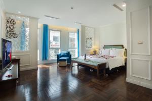 a bedroom with a bed and a table and a tv at Maro Hotel in Hanoi