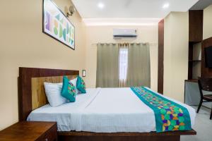 a bedroom with a bed and a table and a television at Treebo Urban Oasis Inn, Sixmile in Guwahati
