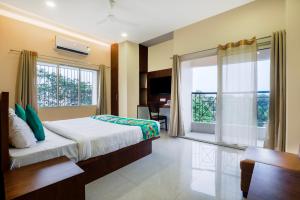 a bedroom with a bed and a large window at Treebo Urban Oasis Inn, Sixmile in Guwahati
