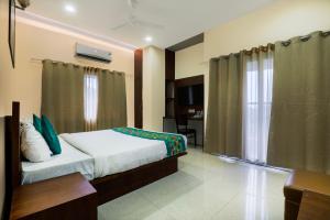 a hotel room with a bed and a window at Treebo Urban Oasis Inn, Sixmile in Guwahati