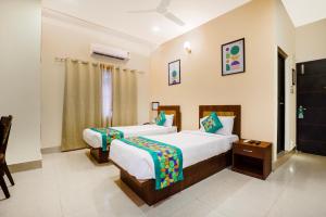 a bedroom with two beds and a window at Treebo Urban Oasis Inn, Sixmile in Guwahati +44 photos