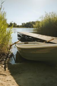 a boat sitting on the water next to a dock at Pokoje nad Dymnem in Koczała