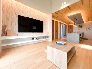 a living room with a tv on a brick wall at Wa no ka in Koga