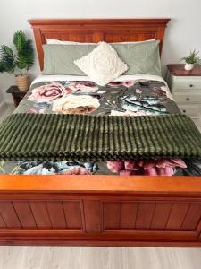 a bed with a wooden frame in a bedroom at Sam's Cottage on Hennessey in Moe