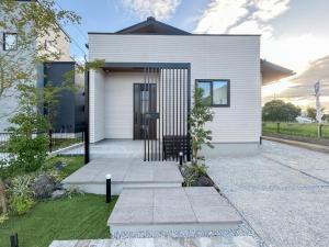 a white house with a black door at Wa no ka in Koga