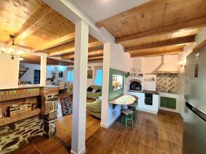 a kitchen and living room with wooden ceilings at Clematis House in Voronet