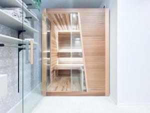 a walk in shower with a wooden door in a bathroom at Wa no ka in Koga