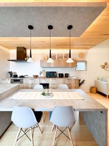a kitchen with a large table and white chairs at Wa no ka in Koga