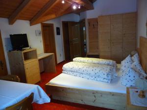 a bedroom with a bed and a tv in it at Gasthof Gemse in Planol