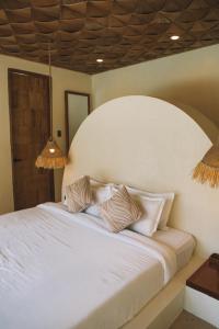 a bedroom with a white bed with two pillows at Baiana Beach Villas in General Luna