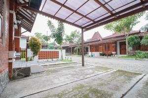 an empty courtyard of a house with awning at Joglo Prambanan B3 in Bugisan +23 photos