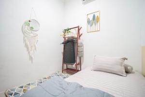 a white room with a bed and a mirror at Joglo Prambanan B3 in Bugisan