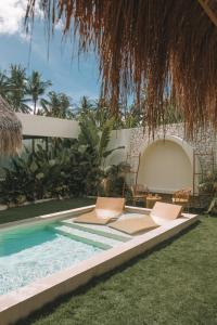 two chairs and a swimming pool in a backyard at Baiana Beach Villas in General Luna