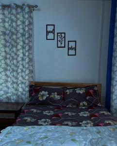 a bedroom with a bed with four pictures on the wall at Padma Riverside Homestay Tabakoshi in Mirik