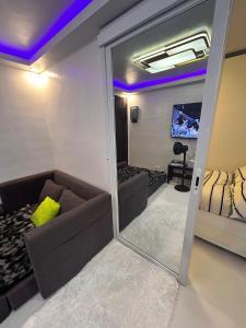 a living room with a couch and a mirror at DG Luxe Suites - Cabanatuan in Bangad