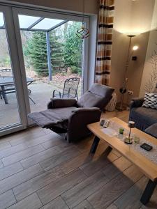 a living room with a couch and a table at Ferienhaus Doris Seeblick in Tannenhausen