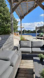 a wooden bench sitting under a pergola on a beach at Ferienhaus Doris Seeblick in Tannenhausen