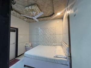 a bedroom with a bed in a room with a ceiling at Hotel kingspalace and Dormitory in Vapi