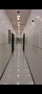 a hallway of a building with white walls and lights at Hotel kingspalace and Dormitory in Vapi