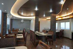 a dining room with tables and chairs in a restaurant at Ymoon Mountain Resort Wayanad in Koroth