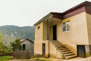 a house with a staircase leading up to a door at Forest in Khulo